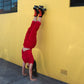 rollerskater doing a handstand wearing Chuffed Skates black roller skates on yellow wall